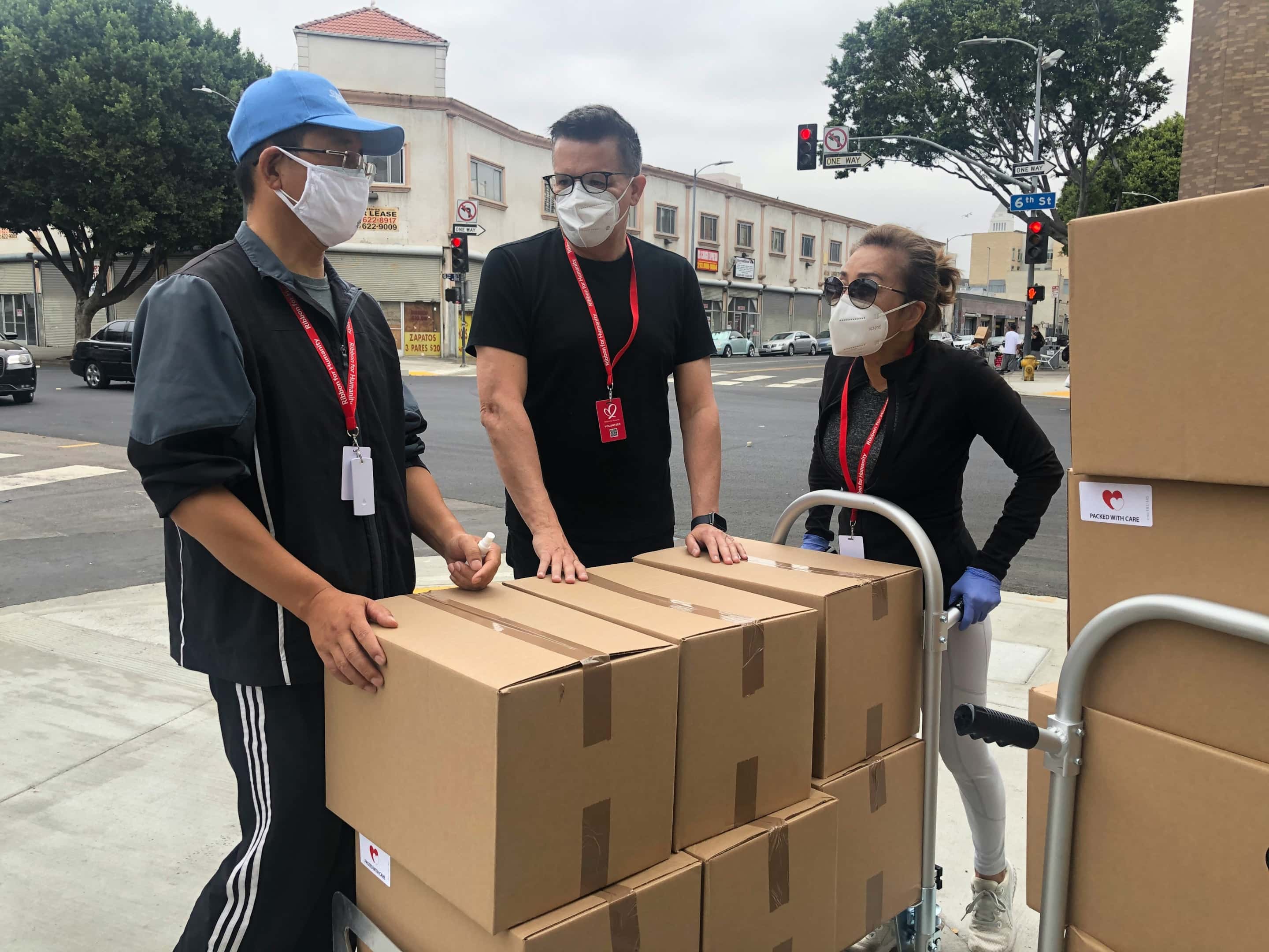 3-men-in-black-polo-shirt-standing-beside-brown-cardboard-boxes